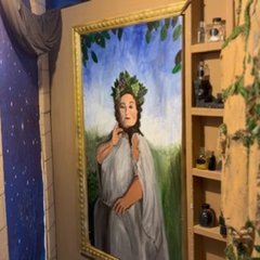 A painted portrait in a gold frame beside shelves of potion bottles in the Magical Mayhem escape room