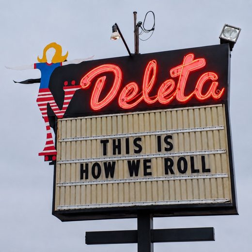 Deleta's neon roadside sign with the marquee reading This Is How We Roll